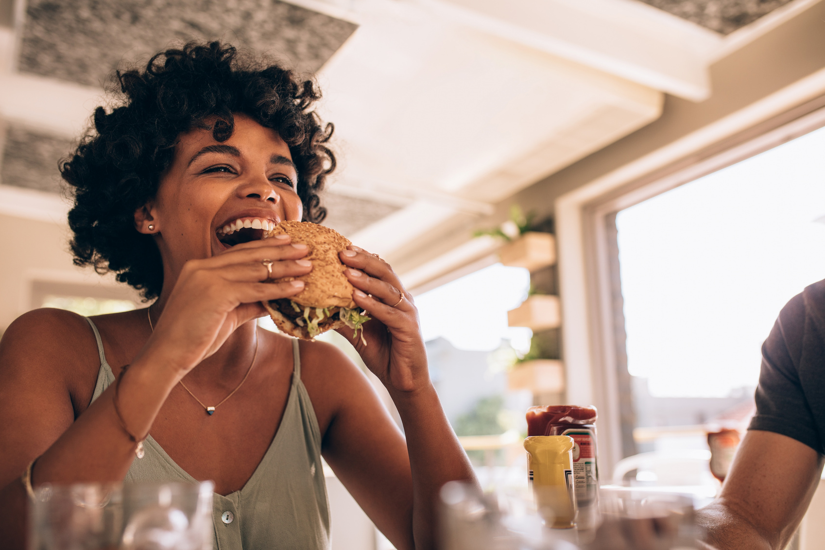 Woman Eating Burger at Restaurant